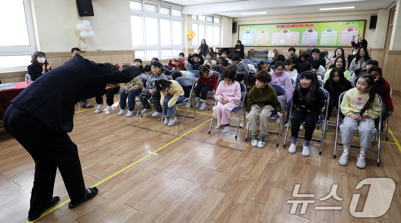 (부산=뉴스1) 윤일지 기자 = 20일 부산 사상구 괘법초등학교 동백관에서 열린 감전초와의 통합 전 이별식에서 교장 선생님이 손으로 하트를 만들며 재학생들에게 작별 인사를 하고 있 …