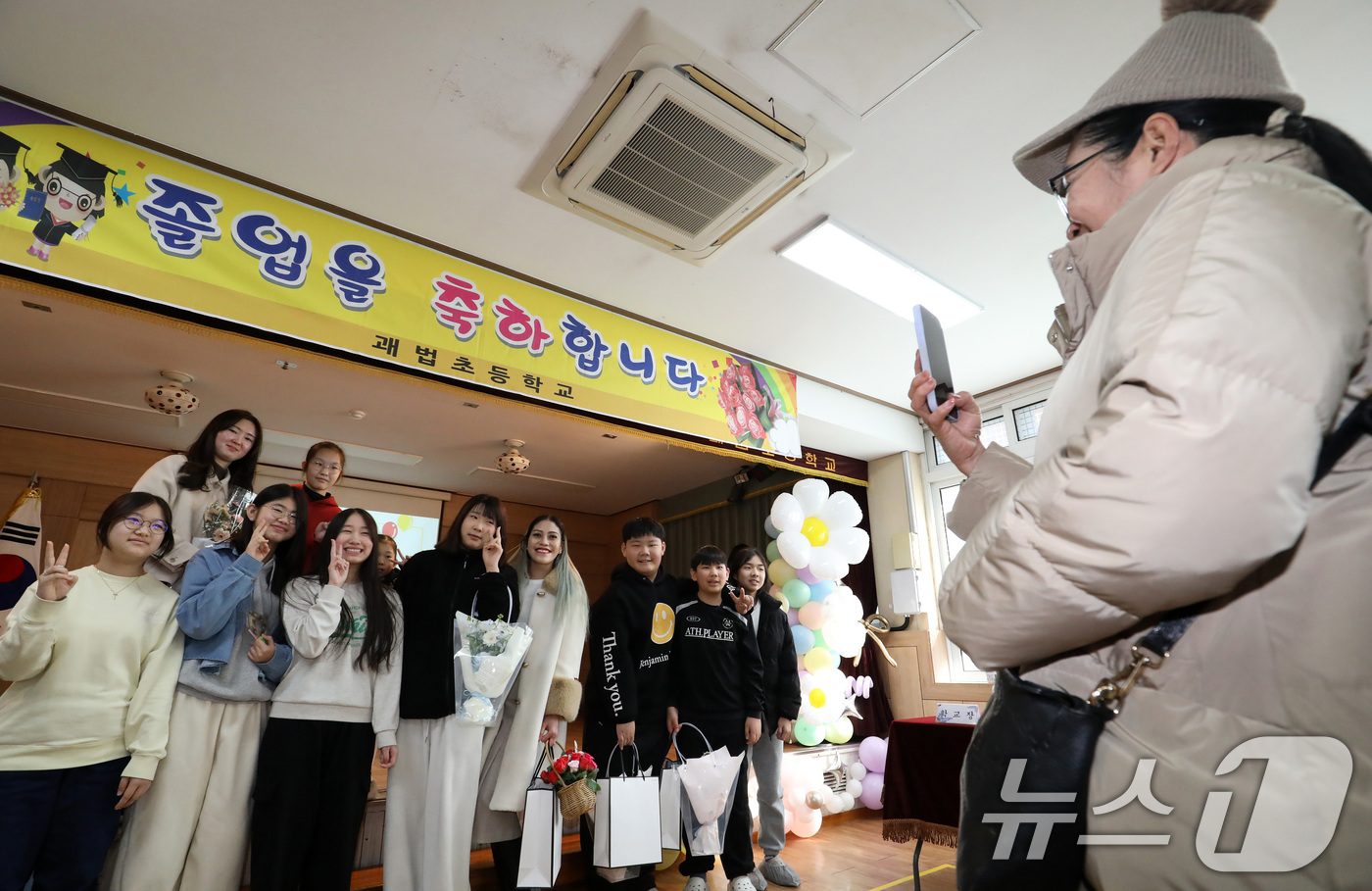 (부산=뉴스1) 윤일지 기자 = 20일 부산 사상구 괘법초등학교 동백관에서 열린 제44회 졸업식에서 졸업생들이 기념촬영을 하고 있다.  저출생으로 인한 학생 수 감소로 폐교가 결정 …