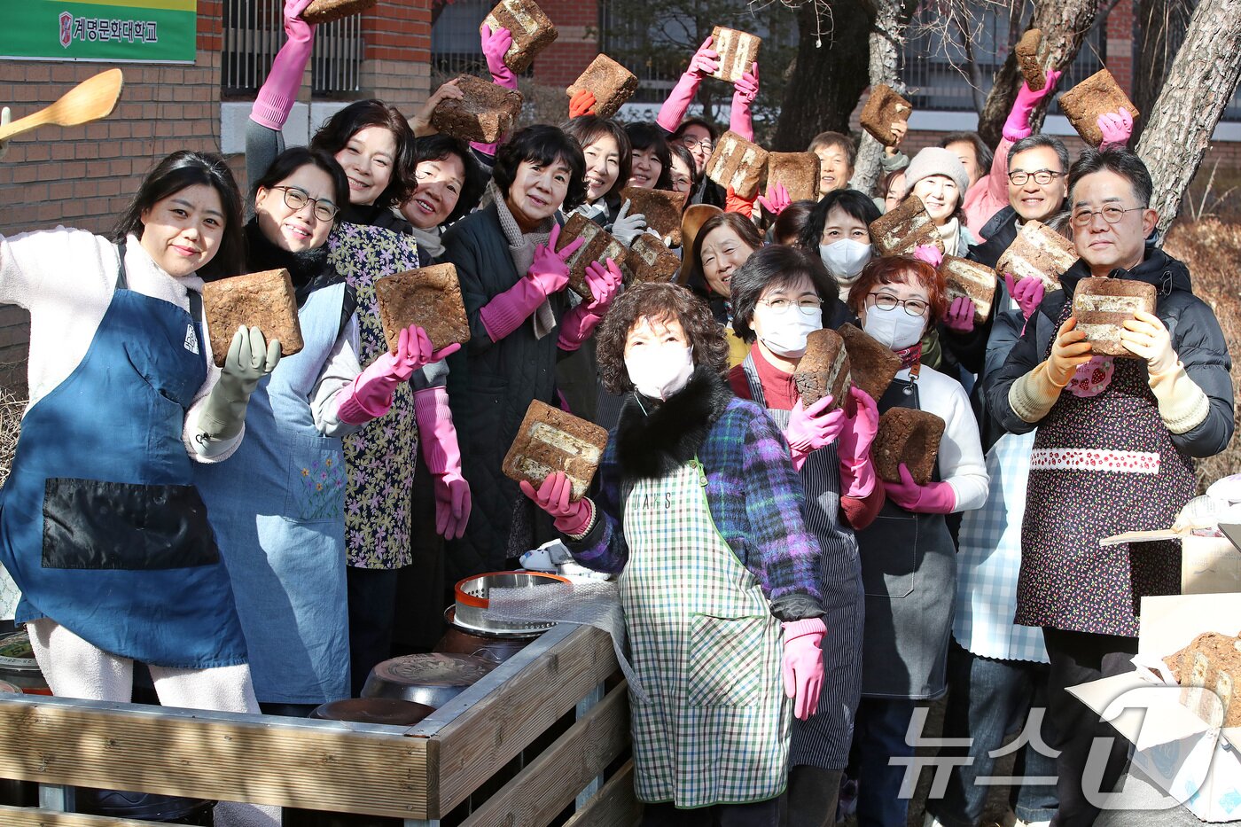 본문 이미지 - 20일 대구 달서구 계명문화대에서 열린 '장 담그기 특강'에 참여한 슬로우푸드조리과 성인학습자와 달서구 주민이 전통 방식으로 장을 담그기에 앞서 메주를 들고 환하게 웃고 있다. 2026.1.20/뉴스1 ⓒ News1 공정식 기자