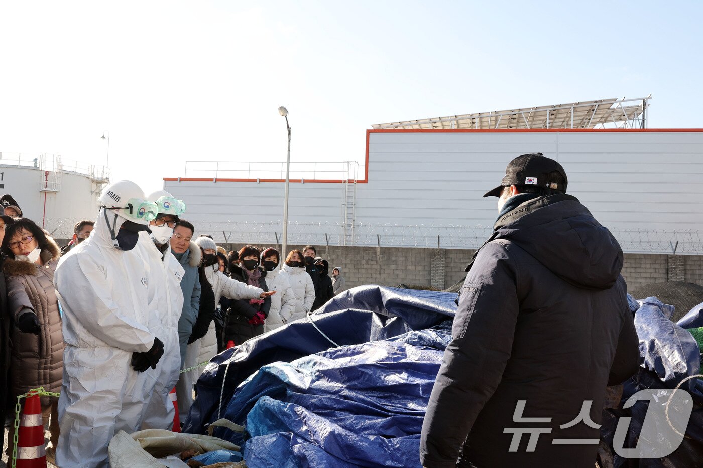 본문 이미지 - 20일 12·29 여객기 참사 진상규명을 위한 국정조사 특별위원회 현장조사에서 항철위 관계자들이 무안국제공항 사고 잔해보관소에서 방수포를 들어 내용물을 보여주고 있다. 2026.1.20/뉴스1 ⓒ News1 박지현 기자