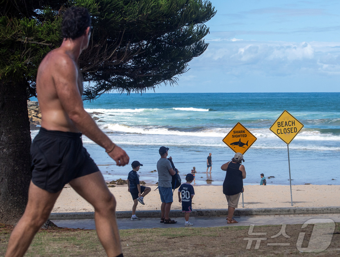 (시드니 로이터=뉴스1) 이정환 기자 = 20일(현지시간) 호주 시드니 퀸즈클리프 해변에서 해변 이용객들이 최근 상어 공격으로 폐쇄된 해변을 알리는 경고 표지판을 지나가고 있다. …
