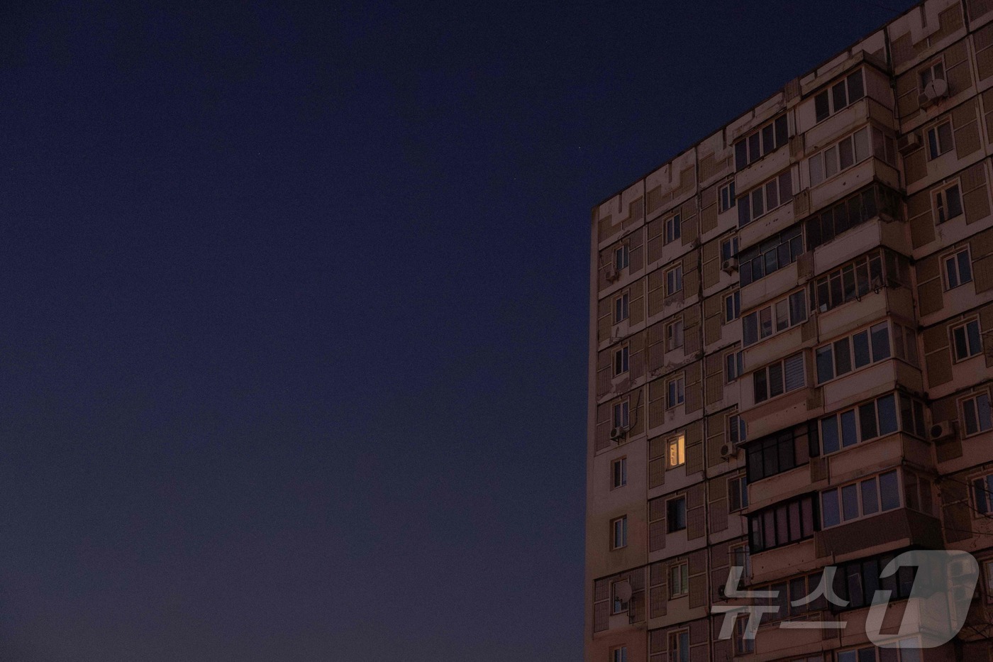 (키이우 AFP=뉴스1) 이창규 기자 = 러시아가 20일(현지시간) 우크라이나의 에너지 인프라 시설을 공습한 후 난방과 물 공급이 끊겼다. 키이우의 주거용 건물 창문에 실내 불이 …