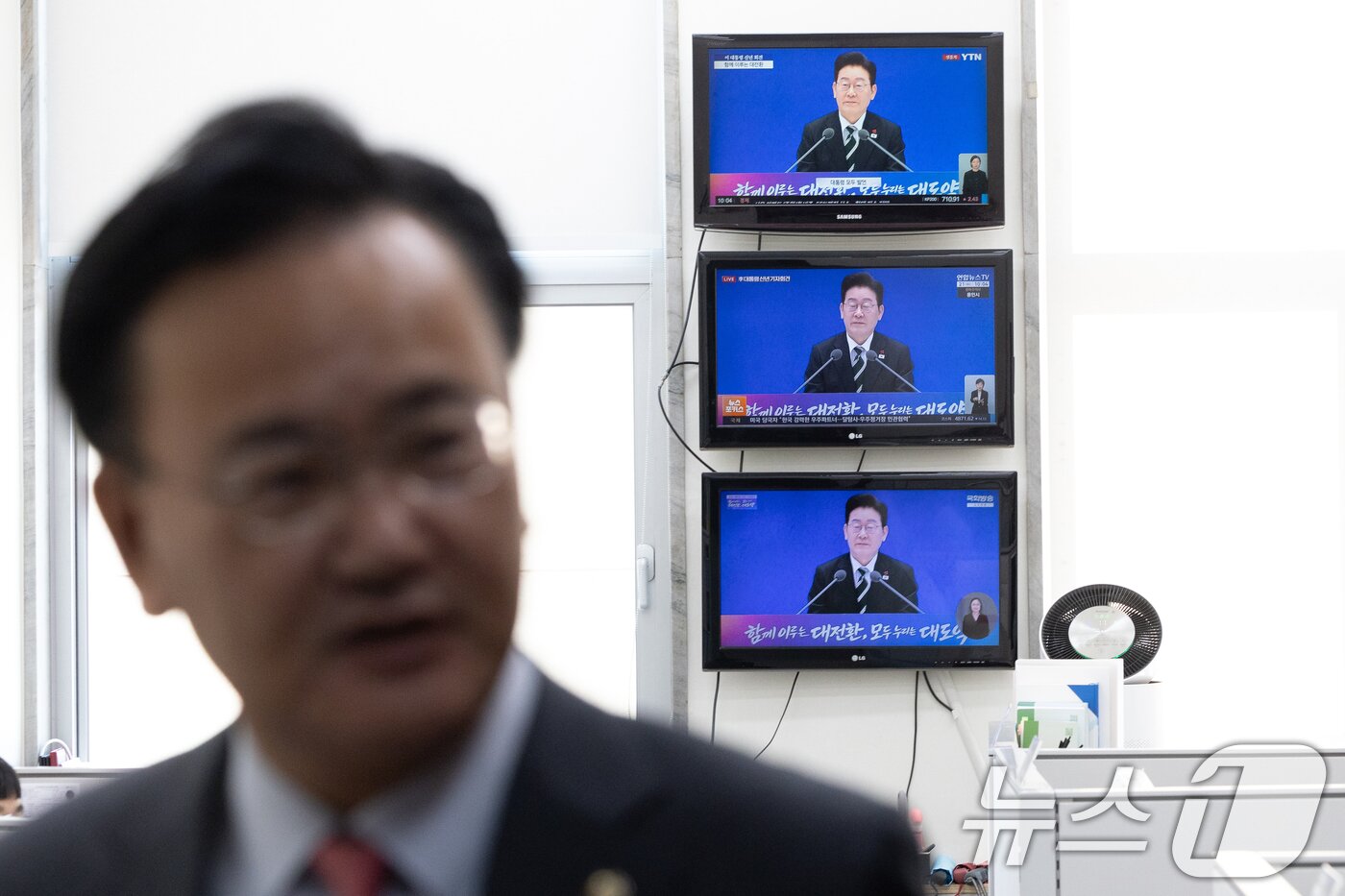 본문 이미지 - 21일 서울 여의도 국회 국민의힘 원내대표실에 마련된 TV에서 이재명 대통령 신년회견 방송이 중계되는 가운데 유상범 국민의힘 원내수석이 발걸음을 옮기고 있다. 2026.1.21/뉴스1 ⓒ News1 이승배 기자