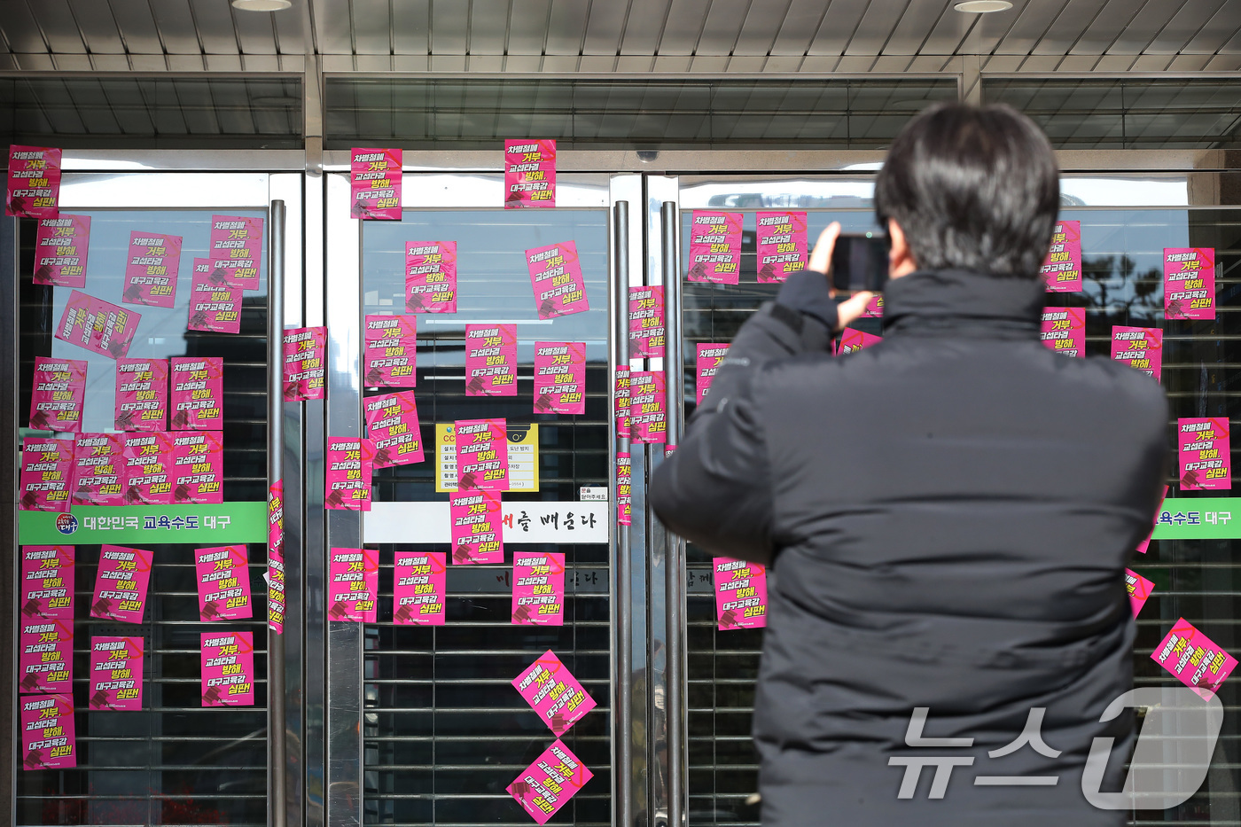 (대구=뉴스1) 공정식 기자 = 21일 오후 전국교육공무직본부 대구지부(대구 학비노조) 관계자들이 대구 수성구 대구교육청 본관 출입문에 '차별철폐 거부, 교섭타결 방해' 등 강은희 …