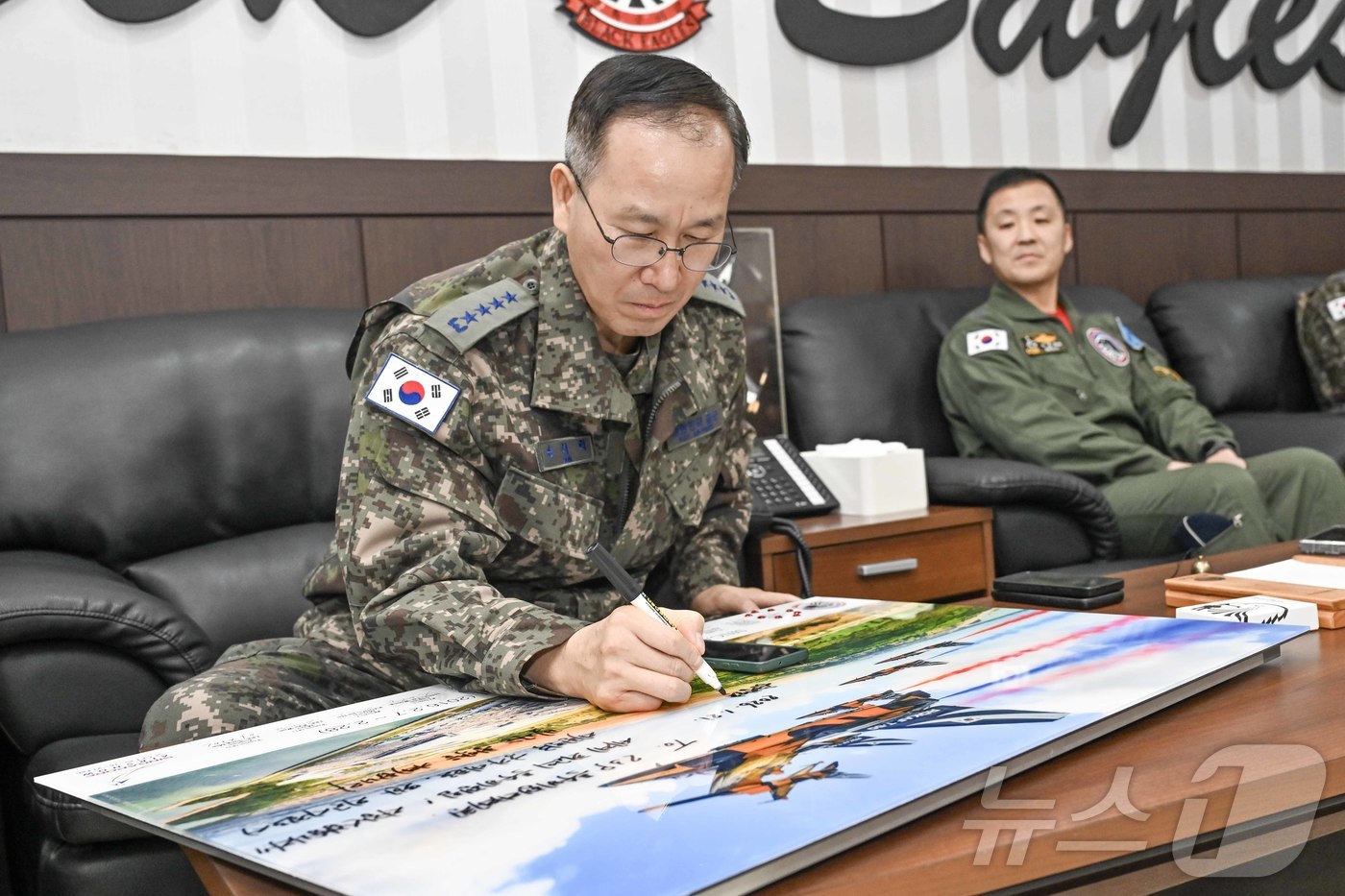 (서울=뉴스1) = 손석락 공군참모총장이 21일 제53특수비행전대를 찾아 사우디 국제방위산업 전시회 2026 참가를 앞둔 블랙이글스 조종사들을 격려하는 메세지를 작성하고 있다. ( …