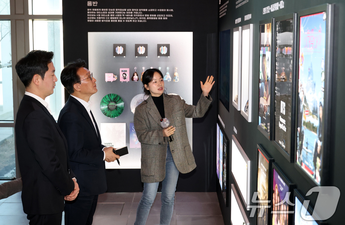 (서울=뉴스1) 임세영 기자  청사사진기자단 = 김민석 국무총리가 21일 오후 서울 용산구 하이브 사옥을 방문해 관계자의 설명을 들으며 홍보물을 살펴보고 있다. 2026.1.21/ …