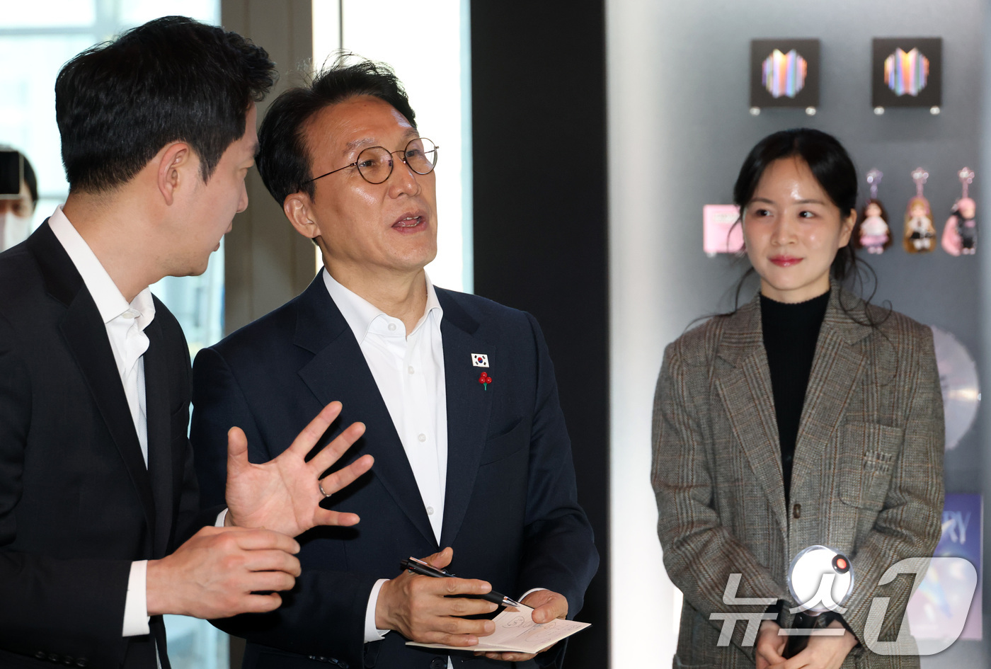 (서울=뉴스1) 청사사진기자단 = 김민석 국무총리가 21일 오후 서울 용산구 하이브 사옥을 방문해 이재상 하이브 대표이사의 설명을 들으며 홍보물을 살펴보고 있다. 2026.1.21 …