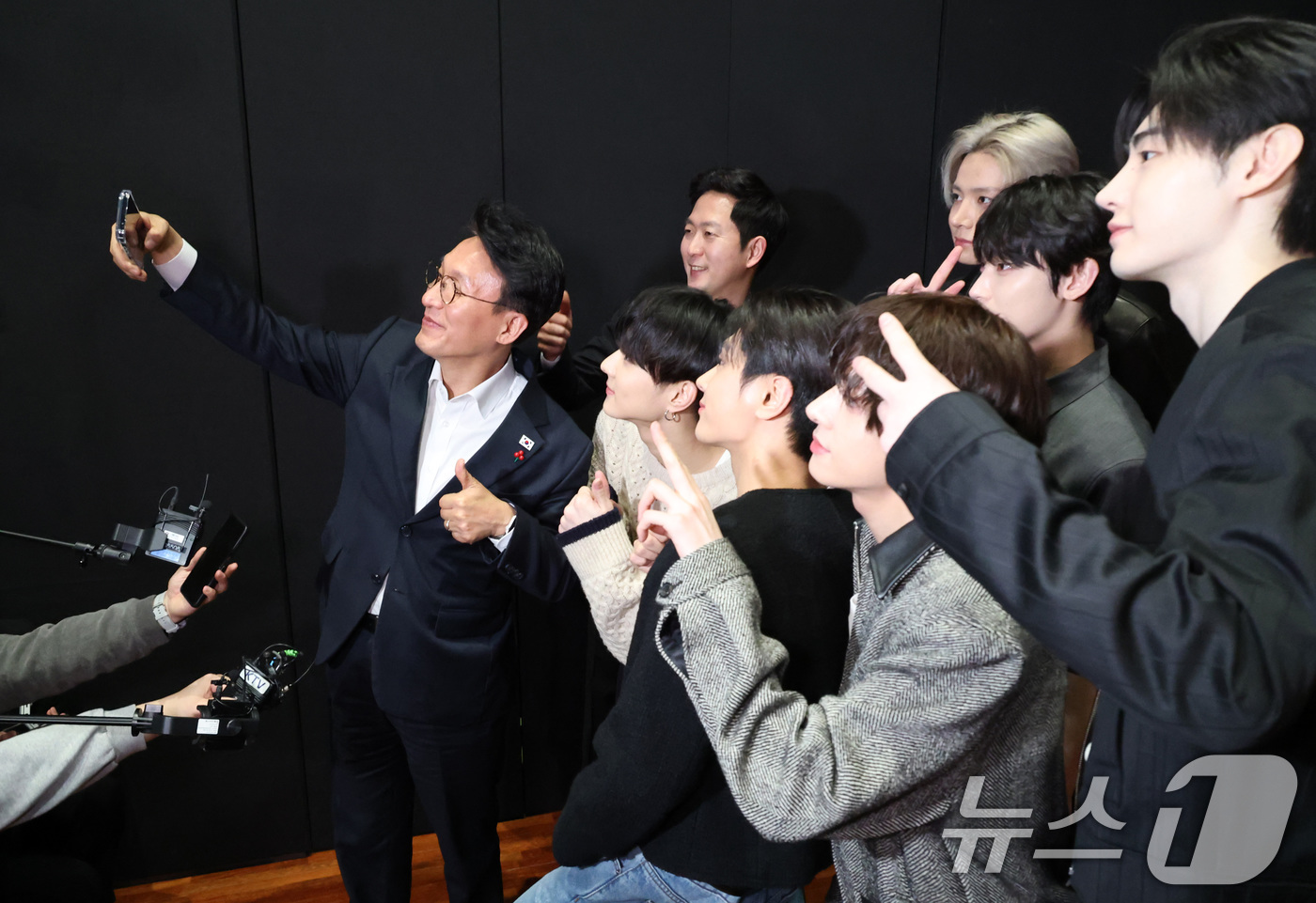 (서울=뉴스1) 청사사진기자단 = 김민석 국무총리가 21일 오후 서울 용산구 하이브 사옥 안무연습실을 방문해 보이그룹 엔하이픈과 셀카를 찍고 있다. 2026.1.21/뉴스1