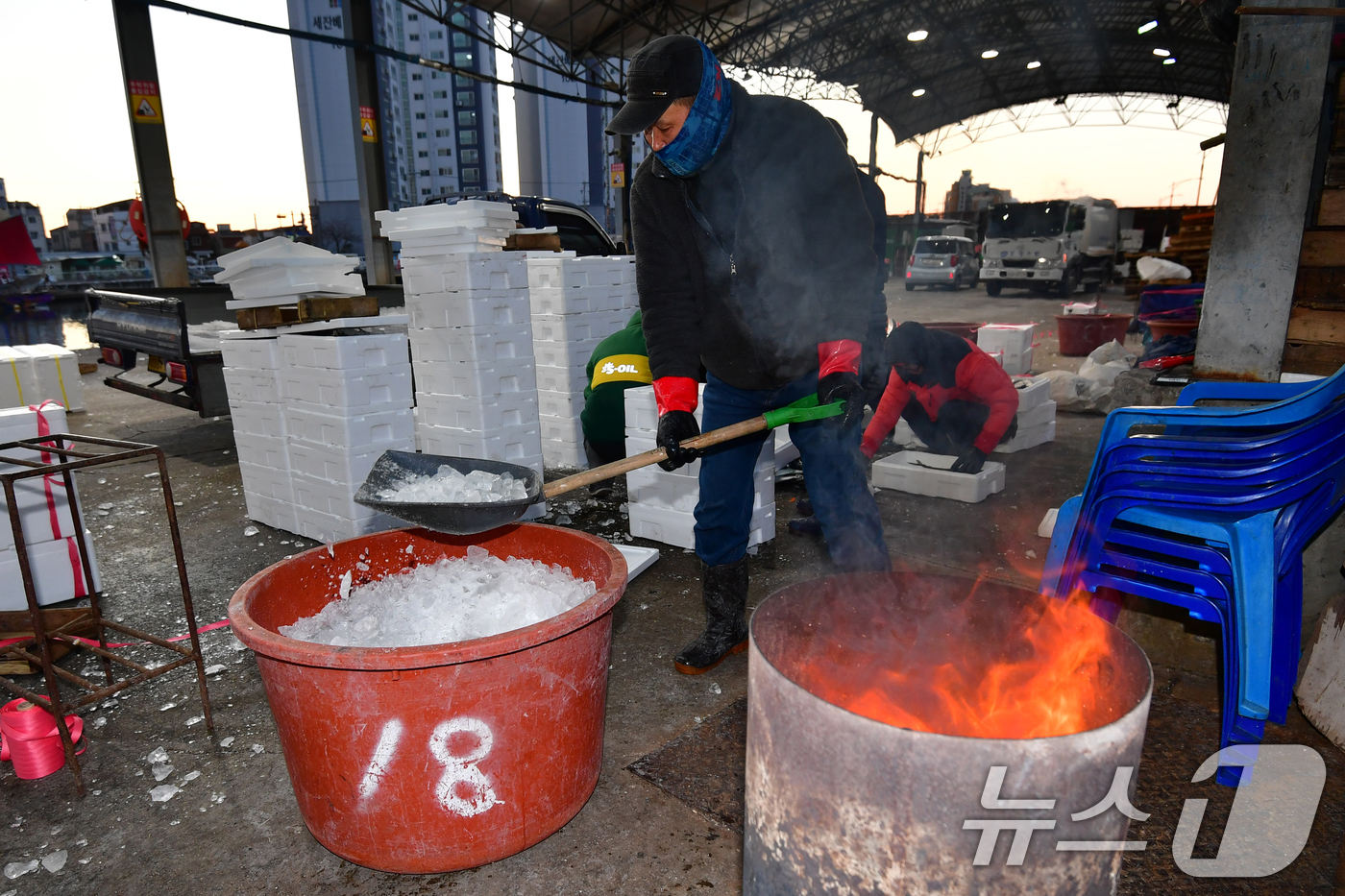 (포항=뉴스1) 최창호 기자 = 22일 경북 포항시 죽도어시장 위판장에서 상인들이 모닥불 옆에서 생선 상자에 넣을 얼음을 준비하고 있다.이날 포항지역 아침 최저기온은 영하 9도 체 …