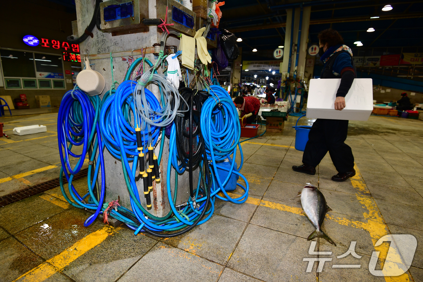 (포항=뉴스1) 최창호 기자 = 22일 경북 포항시 죽도어시장 좌판 상인들이 사용하는 수도호수가 강추위에 얼어 붙은 가운데 한 상인이 장사를 준비하기 위해 걸어가고 있다.이날 포항 …