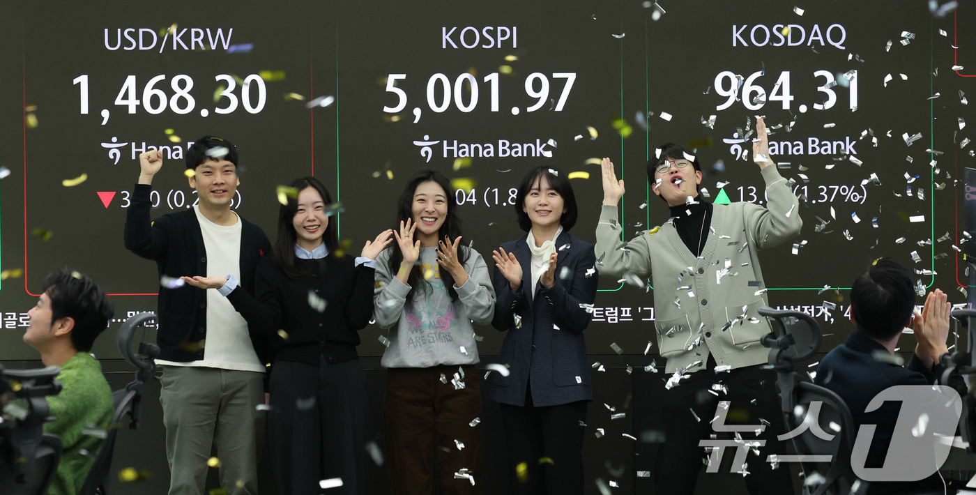 (서울=뉴스1) 박지혜 기자 = 22일 오전 서울 중구 하나은행 본점 딜링룸 현황판에 코스피 지수가 장중 5000p를 넘으며 개장하자 직원들이 환호하고 있다. 2026.1.22/뉴 …