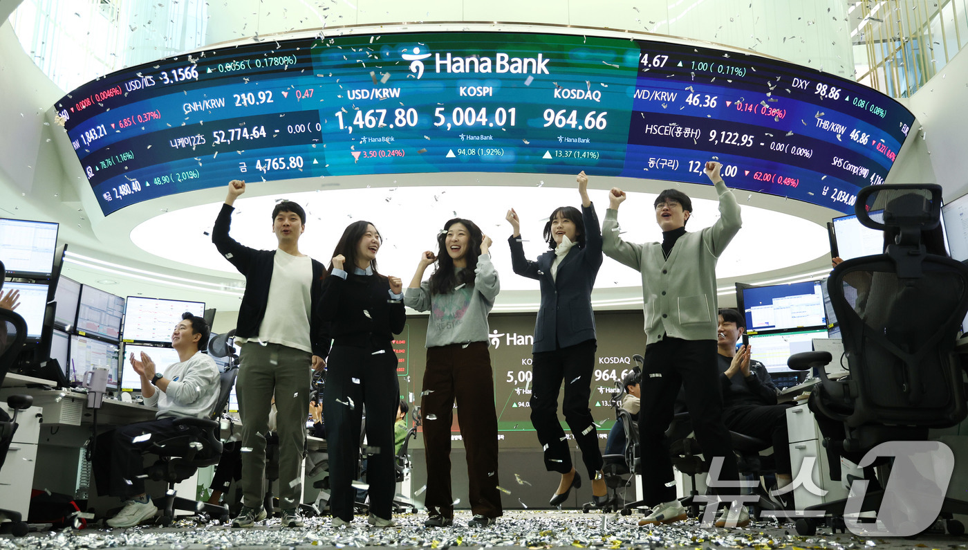 (서울=뉴스1) 박지혜 기자 = 22일 오전 서울 중구 하나은행 본점 딜링룸 현황판에 코스피 지수가 장중 5000p를 넘으며 개장하자 직원들이 환호하고 있다. 2026.1.22/뉴 …