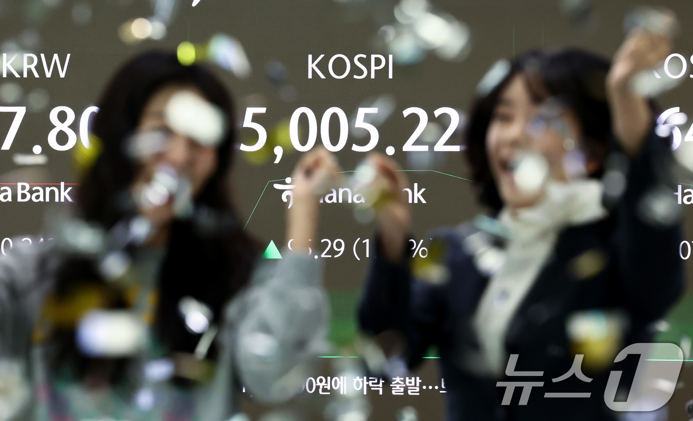 (서울=뉴스1) 최지환 기자 = 22일 오전 서울 중구 하나은행 본점 딜링룸 전광판에 코스피 지수가 장중 5000p를 넘자 직원들이 환호하고 있다. 2026.1.22/뉴스1