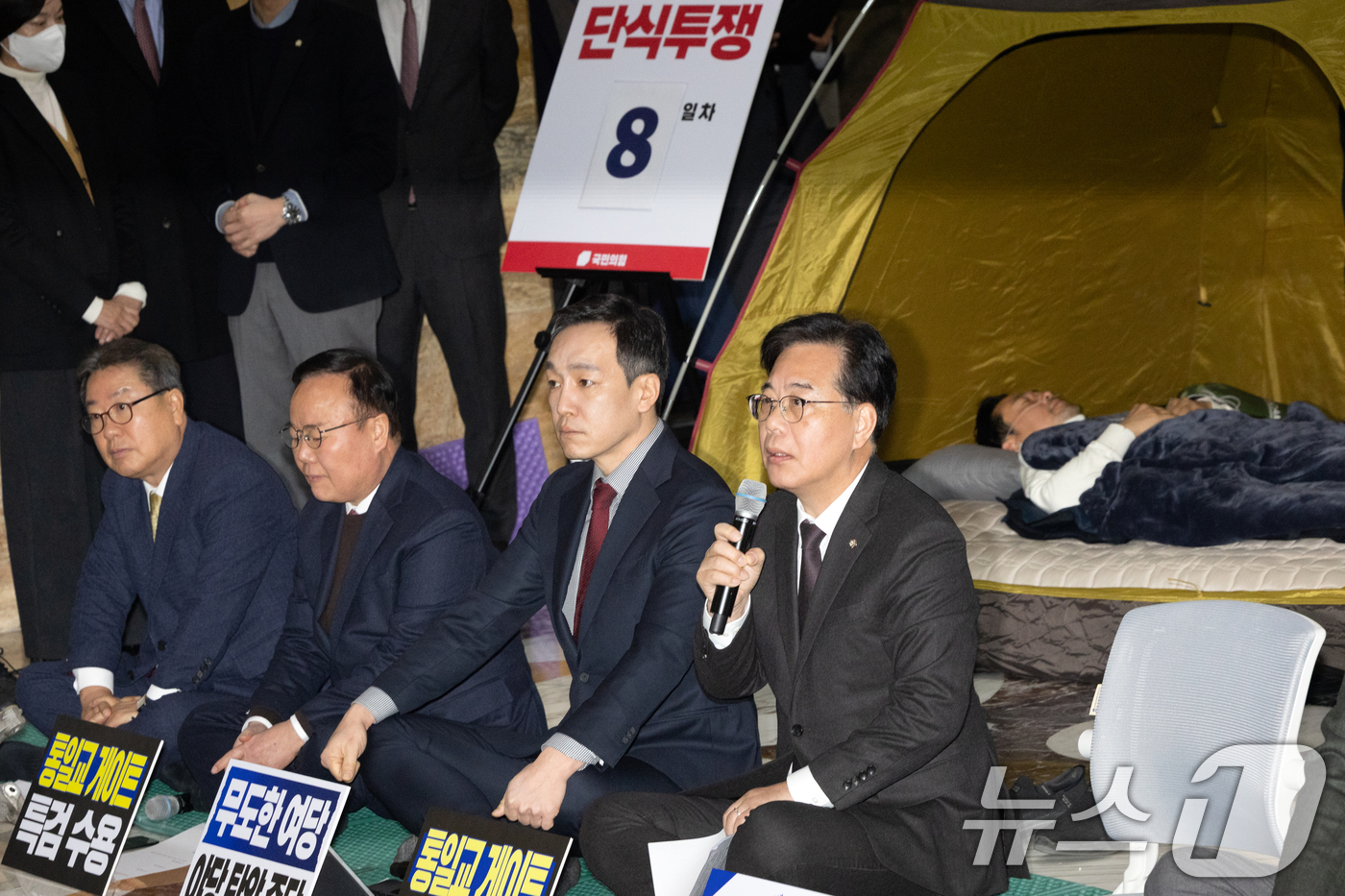 (서울=뉴스1) 이승배 기자 = 송언석 국민의힘 원내대표가 22일 서울 여의도 국회 로텐더홀에서 열린 최고위원회의에서 모두발언하는 가운데 단식 중인 장동혁 대표가 누워서 휴식을 취 …