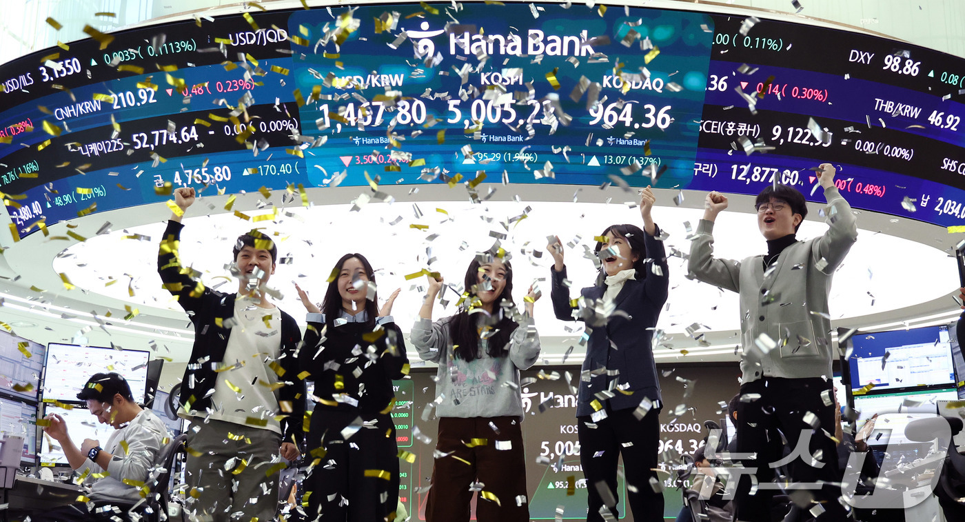 (서울=뉴스1) 박지혜 기자 = 22일 오전 서울 중구 하나은행 본점 딜링룸 현황판에 코스피 지수가 장중 5000p를 넘으며 개장하자 직원들이 환호하고 있다. 2026.1.22/뉴 …