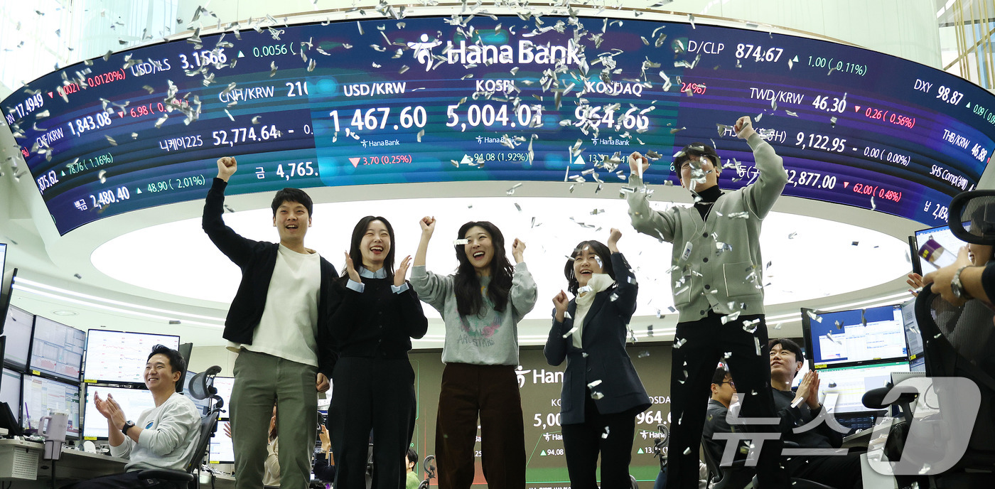 (서울=뉴스1) 박지혜 기자 = 22일 오전 서울 중구 하나은행 본점 딜링룸 현황판에 코스피 지수가 장중 5000p를 넘으며 개장하자 직원들이 환호하고 있다. 2026.1.22/뉴 …