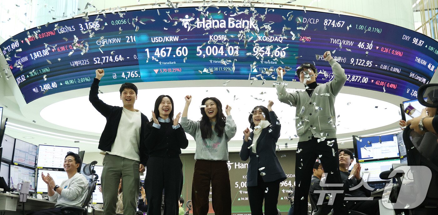 본문 이미지 - 22일 오전 서울 중구 하나은행 본점 딜링룸 현황판에 코스피 지수가 장중 5000p를 넘으며 개장하자 직원들이 환호하고 있다. 2026.1.22/뉴스1 ⓒ News1 박지혜 기자