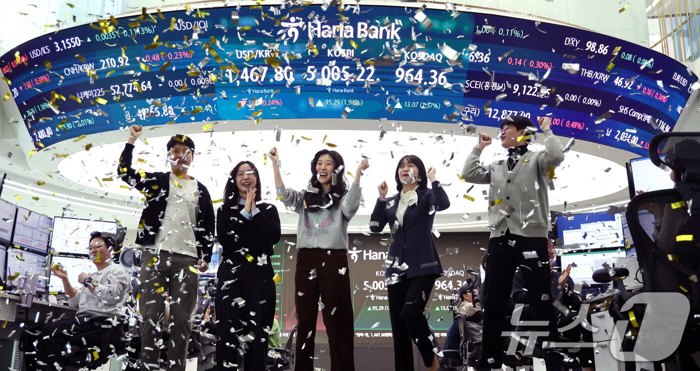 본문 이미지 - 22일 오전 서울 중구 하나은행 본점 딜링룸 현황판에 코스피 지수가 장중 5000p를 넘으며 개장하자 직원들이 환호하고 있다. 2026.1.22/뉴스1 ⓒ News1 박지혜 기자