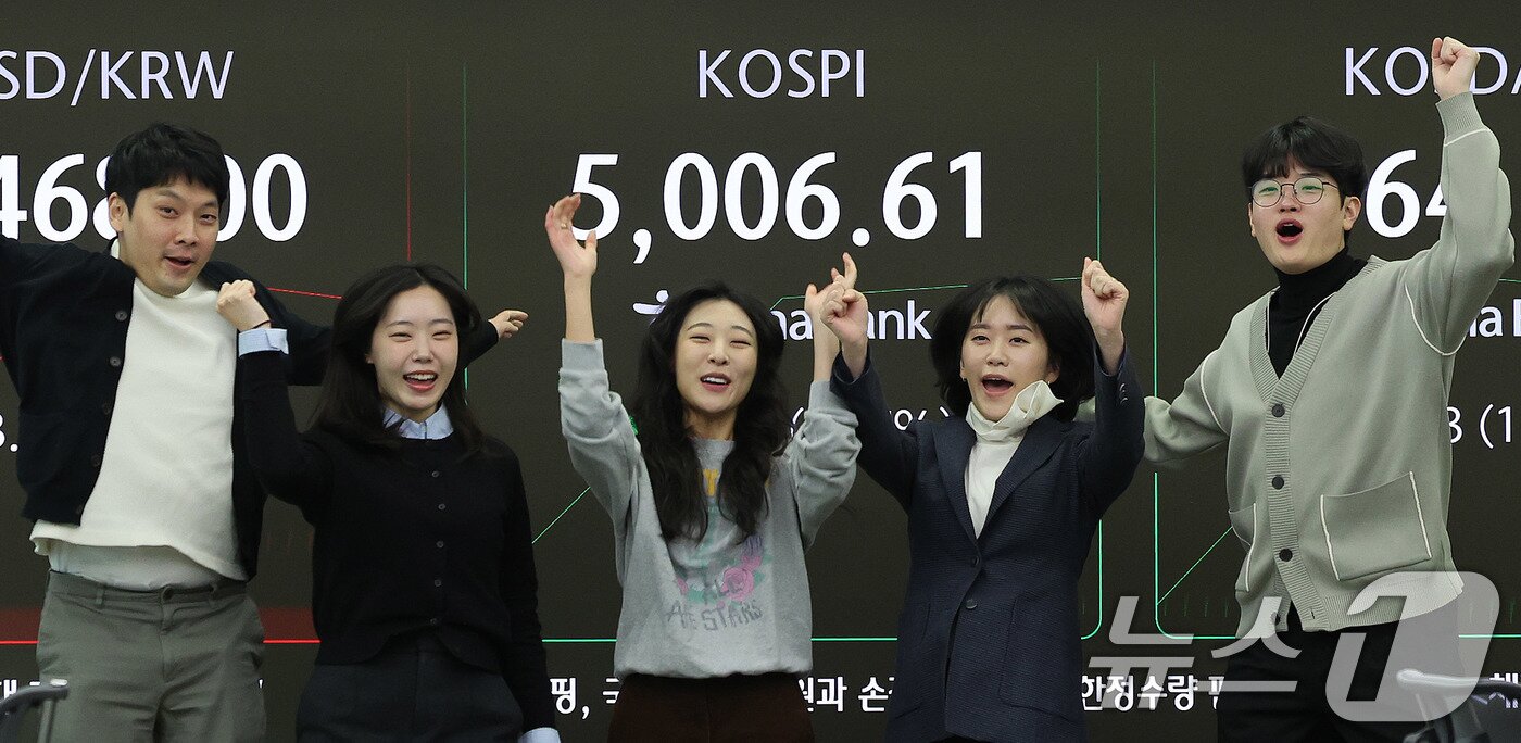 본문 이미지 - 22일 오전 서울 중구 하나은행 본점 딜링룸 현황판에 코스피 지수가 장중 5000p를 넘으며 개장하자 직원들이 환호하고 있다. 2026.1.22/뉴스1 ⓒ News1 박지혜 기자
