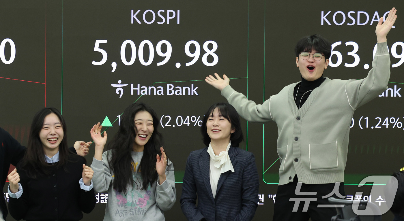 (서울=뉴스1) 박지혜 기자 = 22일 오전 서울 중구 하나은행 본점 딜링룸 현황판에 코스피 지수가 장중 5000p를 넘으며 개장하자 직원들이 환호하고 있다. 2026.1.22/뉴 …