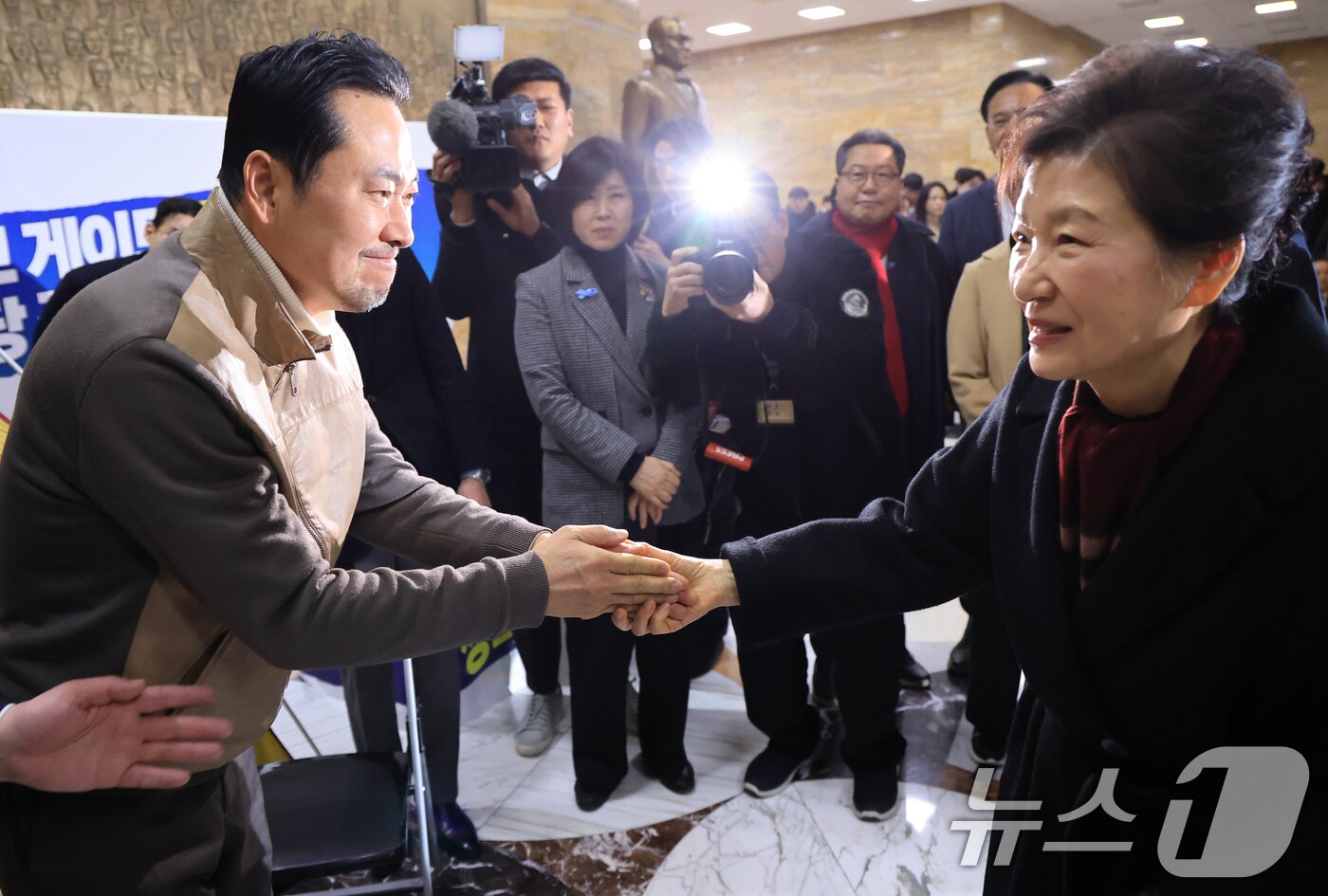 본문 이미지 - 박근혜 전 대통령이 지난 1월 22일 국회 로텐더홀에서 통일교·공천헌금 '쌍특검' 수용을 요구하며 8일째 단식 중인 국민의힘 장동혁 대표를 찾아 인사를 나누고 있다. 2026.1.22 / ⓒ 뉴스1 국회사진기자단