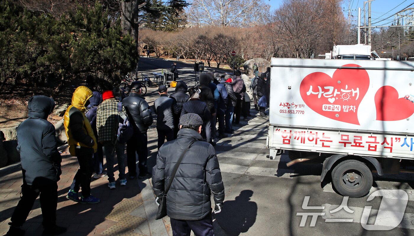 본문 이미지 - 22일 대구 달서구 두류공원 사랑해밥차 무료급식소 앞에서 배식을 기다리는 행렬. 2026.1.22/뉴스1 ⓒ News1 공정식 기자