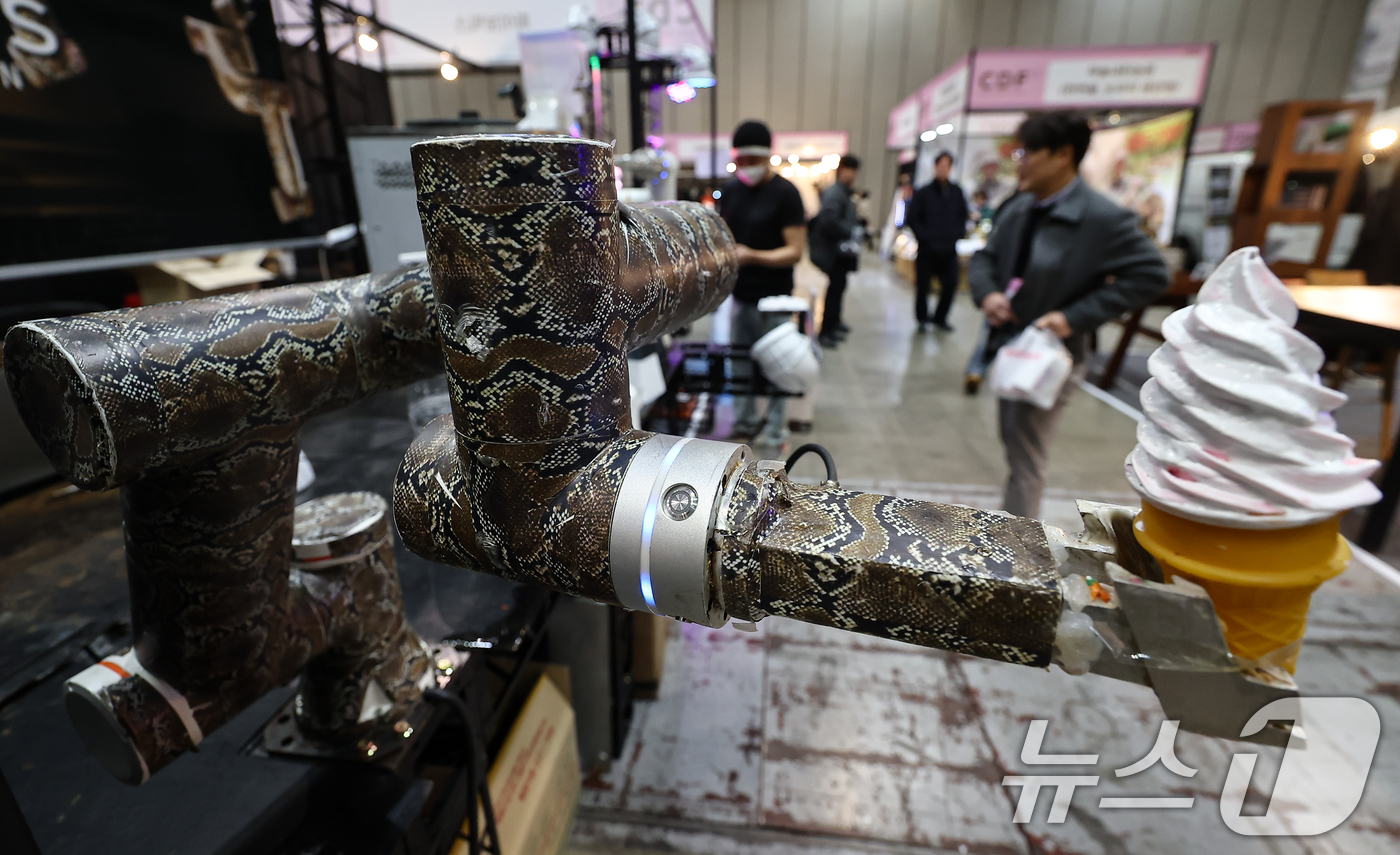 (고양=뉴스1) 김도우 기자 = 22일 경기 고양시 킨텍스에서 열린 2026 카페디저트페어에서 관람객들이 로봇이 전달하는 아이스크림을 지켜보고 있다. 2026.1.22/뉴스1