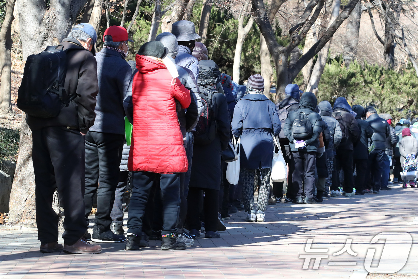 (대구=뉴스1) 공정식 기자 = 매서운 한파가 몰아친 22일 대구 달서구 두류공원 '사랑해밥차' 무료급식소를 찾은 사람들이 줄지어 점심 배식을 기다리고 있다. 2026.1.22/뉴 …
