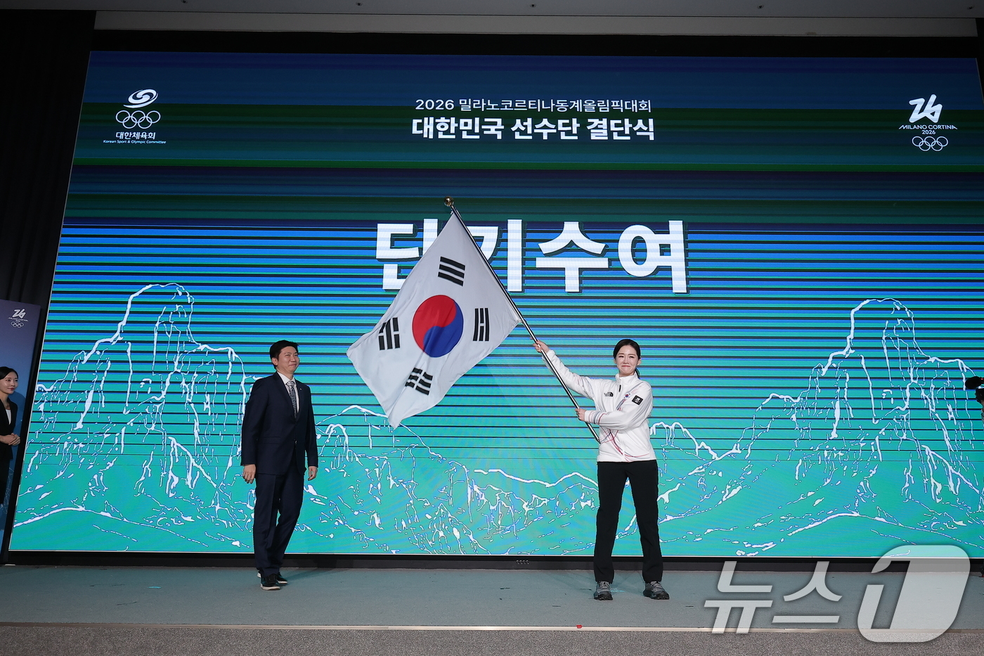 (서울=뉴스1) 김성진 기자 = 이수경 선수단장이 22일 서울 송파구 올림픽파크텔에서 열린 2026 밀라노코르티나 동계올림픽대회 결단식에서 유승민 대한체육회장에게 수여받은 단기를 …