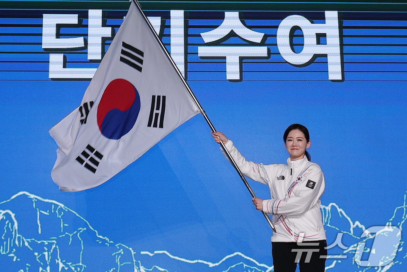 (서울=뉴스1) 김성진 기자 = 이수경 선수단장이 22일 서울 송파구 올림픽파크텔에서 열린 2026 밀라노코르티나 동계올림픽대회 결단식에서 유승민 대한체육회장에게 수여받은 단기를 …