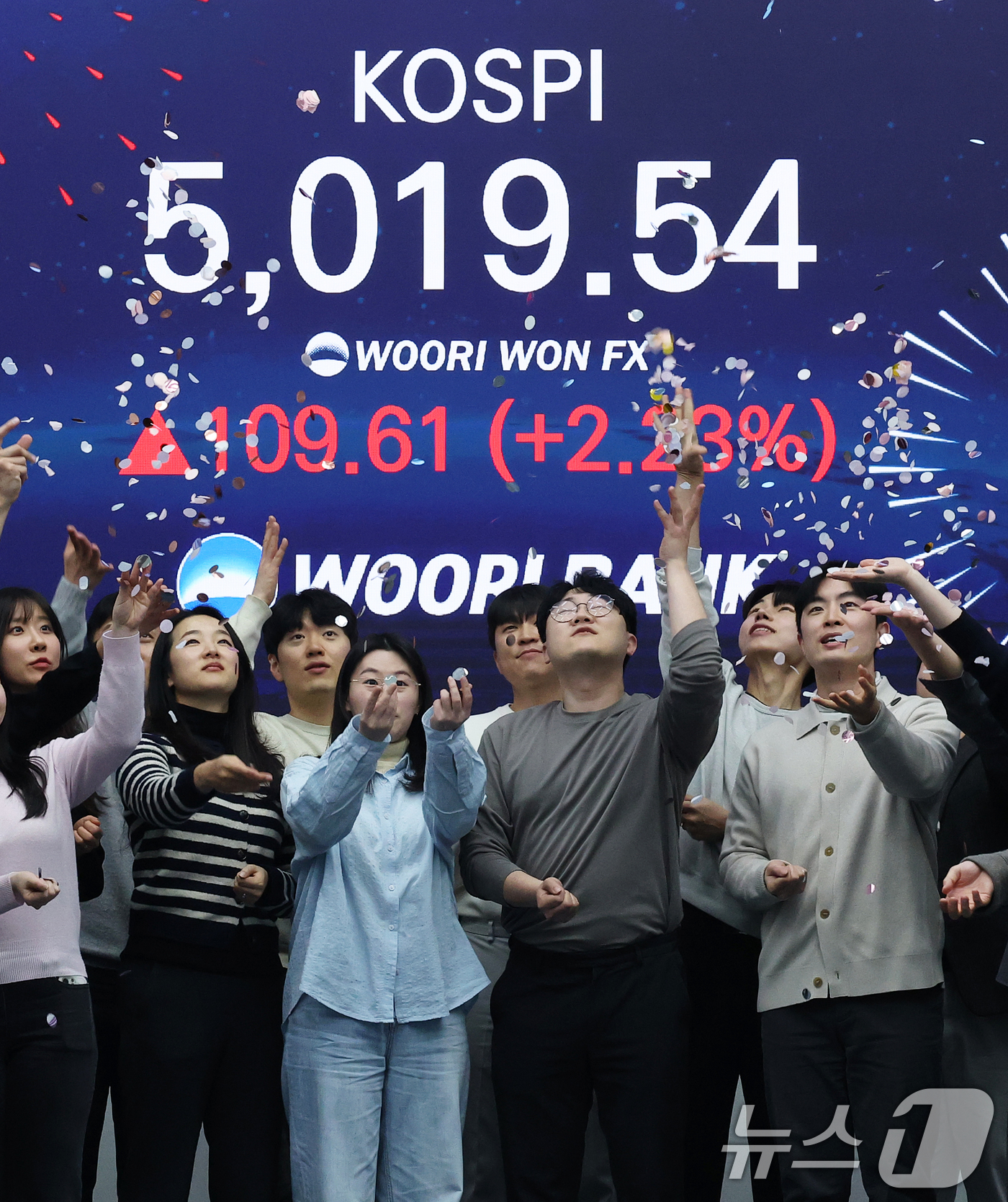 (서울=뉴스1) 오대일 기자 = 한국 증시가 사상 처음으로 '코스피 5000' 쾌거를 달성한 22일 서울 중구 우리은행 본점 딜링룸에서 직원들이 장중 최고가가 찍힌 전광판을 배경으 …