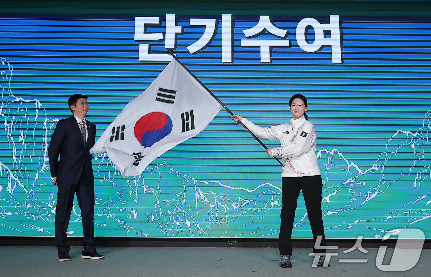 (서울=뉴스1) 김성진 기자 = 이수경 선수단장이 22일 서울 송파구 올림픽파크텔에서 열린 2026 밀라노코르티나 동계올림픽대회 결단식에서 유승민 대한체육회장에게 수여받은 단기를 …