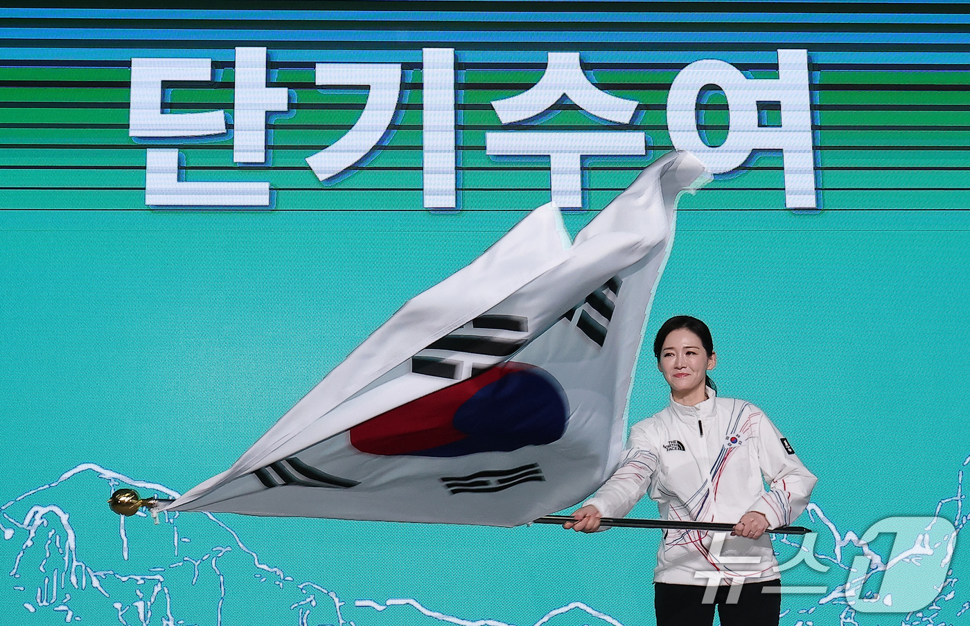 (서울=뉴스1) 김성진 기자 = 이수경 선수단장이 22일 서울 송파구 올림픽파크텔에서 열린 2026 밀라노코르티나 동계올림픽대회 결단식에서 유승민 대한체육회장에게 수여받은 단기를 …