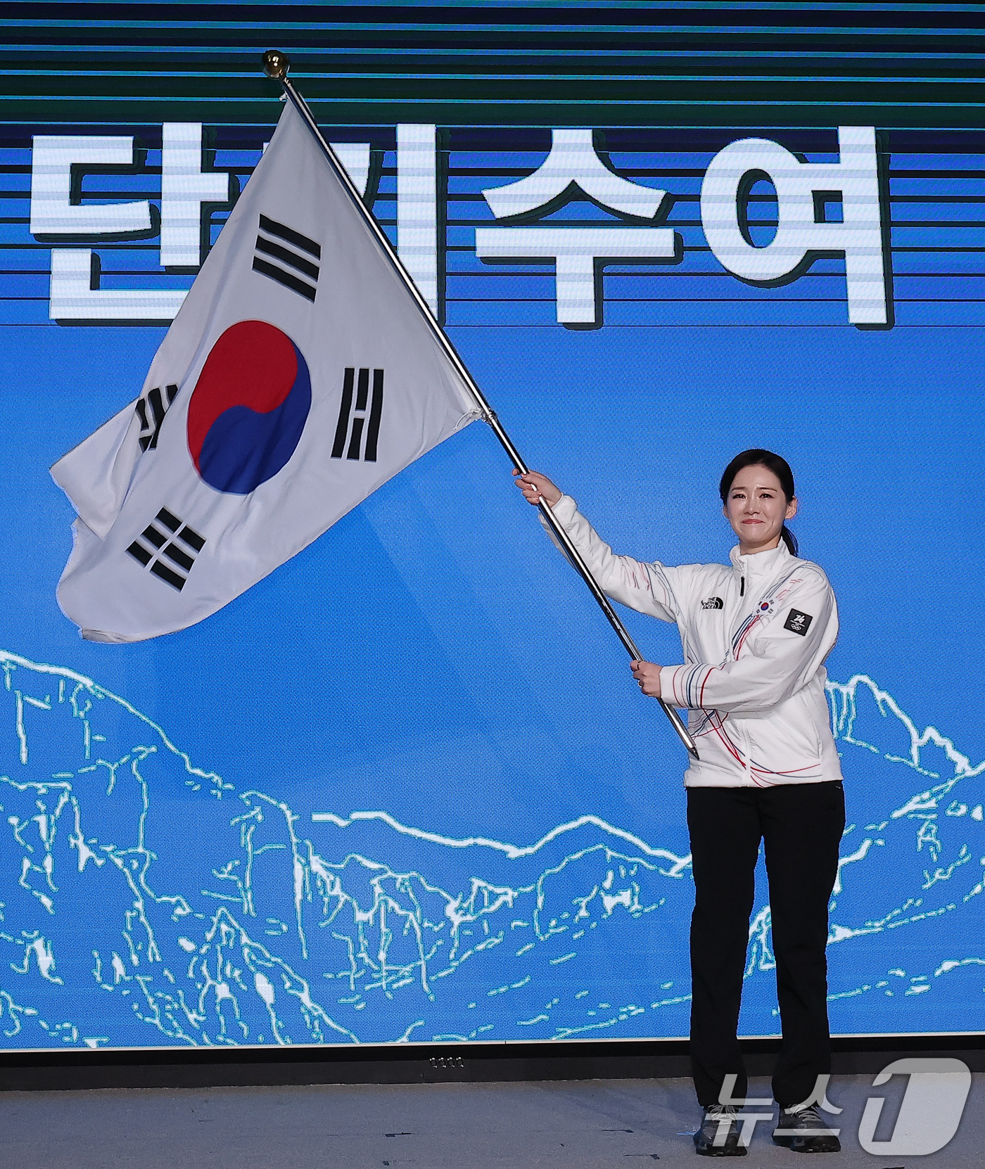 (서울=뉴스1) 김성진 기자 = 이수경 선수단장이 22일 서울 송파구 올림픽파크텔에서 열린 2026 밀라노코르티나 동계올림픽대회 결단식에서 유승민 대한체육회장에게 수여받은 단기를 …