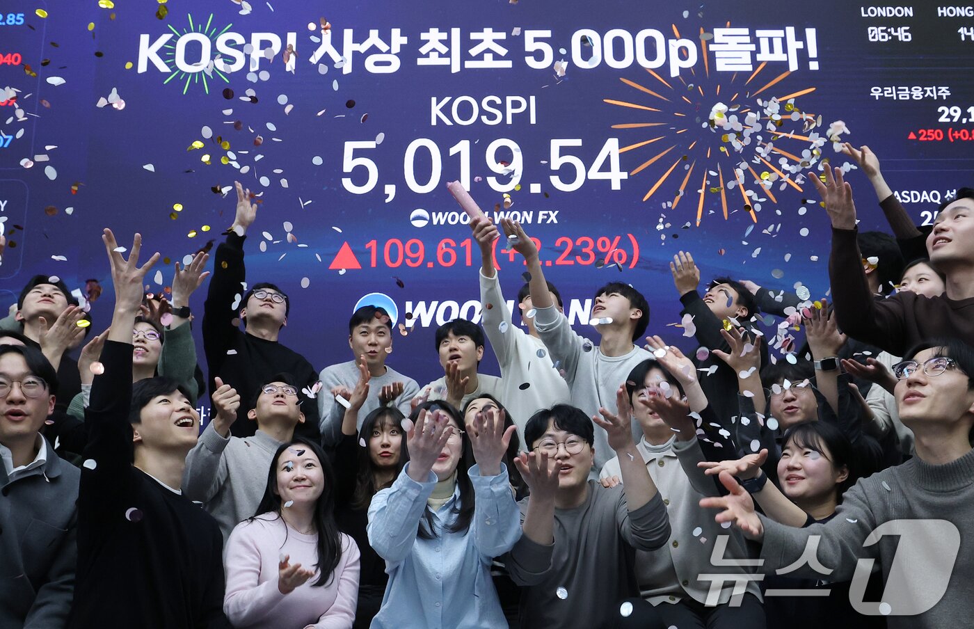 본문 이미지 - 한국 증시가 사상 처음으로 '코스피 5000' 쾌거를 달성한 지난 22일 서울 중구 우리은행 본점 딜링룸에서 직원들이 장중 최고가가 찍힌 전광판을 배경으로 코스피 5000 돌파를 축하하고 있다. 2026.1.22/뉴스1 ⓒ News1 오대일 기자