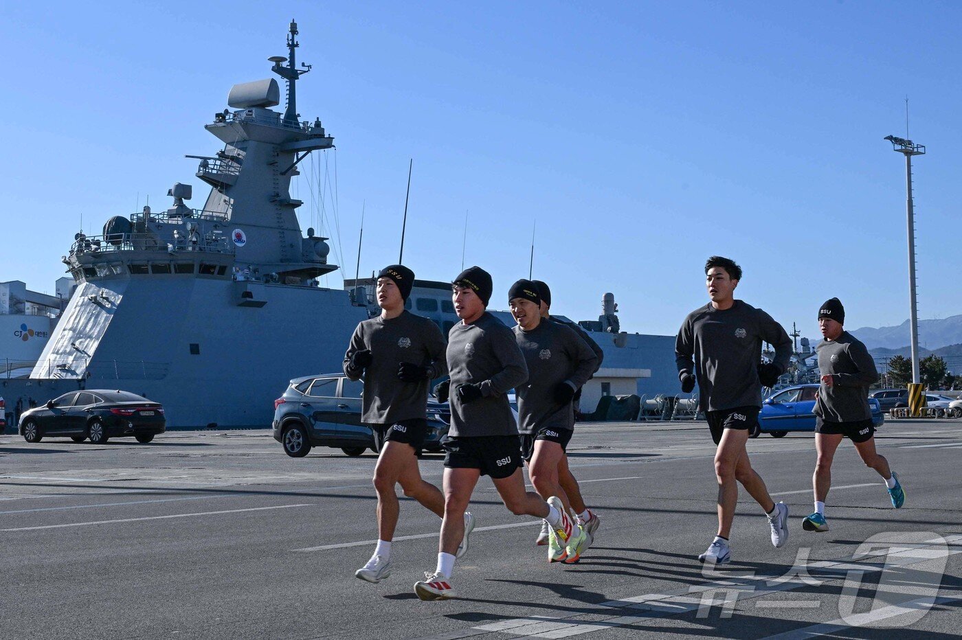 본문 이미지 - 22일 철인 심해잠수팀 선발 경기 종목인 5㎞ 달리기에서 해군 SSU 5구조작전중대 대원들이 혹한기 동해안의 칼바람을 가르며 동해군항 1부두를 질주하고 있다.(해군1함대 제공, 재판매 및 DB 금지) 2026.1.22/뉴스1 