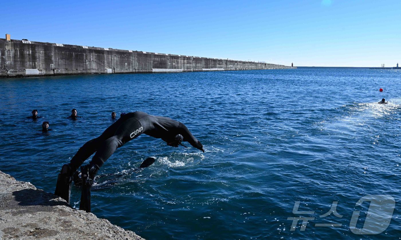 본문 이미지 - 22일 강원 동해시 동해군항 1부두에서 SSU 5구조작전중대 대원들이 철인 심해잠수팀 선발 경기 마지막 종목인 릴레이 수영에 나서 차가운 바다로 몸을 던지고 있다.(해군1함대 제공, 재판매 및 DB 금지) 2026.1.22/뉴스1