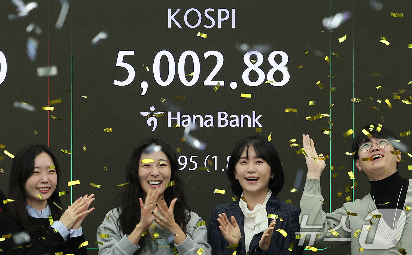 (서울=뉴스1) 박지혜 기자 = 코스피지수가 사상 처음으로 장중 5000을 돌파한 22일 오전 서울 을지로 하나은행 딜링룸에서 직원들이 신기록 달성을 축하하고 있다. 이날 코스피지 …