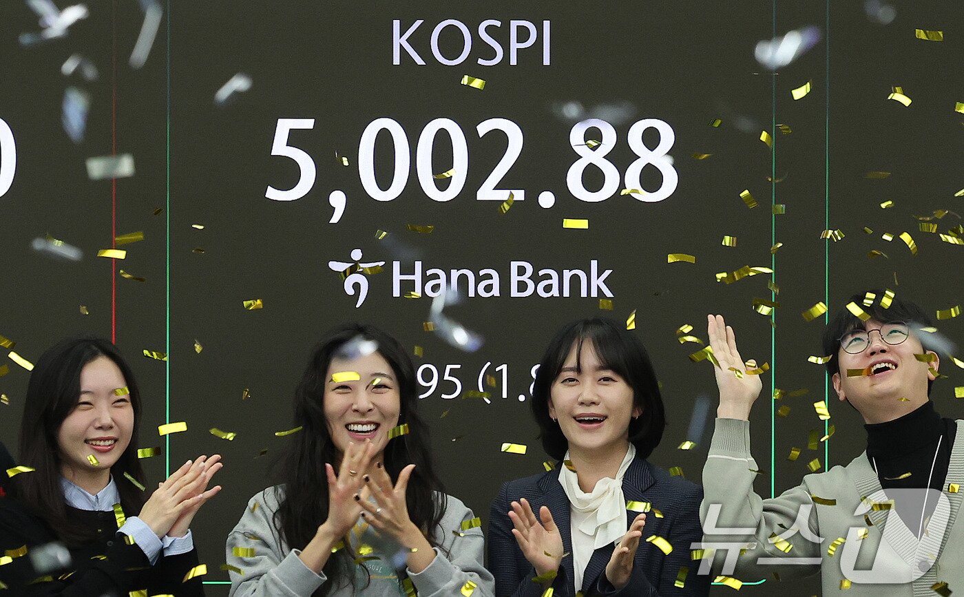 본문 이미지 - 코스피지수가 사상 처음으로 장중 5000을 돌파한 지난 22일 오전 서울 을지로 하나은행 딜링룸에서 직원들이 신기록 달성을 축하하고 있다. 2026.1.22/뉴스1 ⓒ News1 박지혜 기자