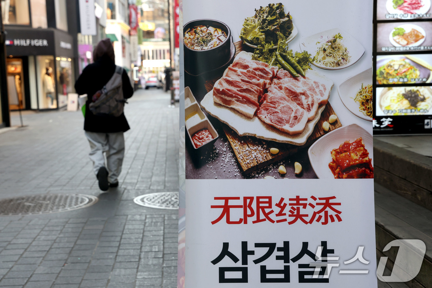 (서울=뉴스1) 이광호 기자 = 23일 서울 중구 명동에서 시민이 한식당 앞을 지나가고 있다.한국소비자원 가격정보포털 참가격에 따르면 지난해 1년 동안 외식비는 최대 5%이상 상승 …