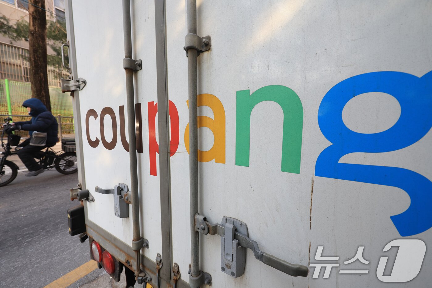 본문 이미지 - 서울시내에 주차된 쿠팡배송 차량 앞을 시민이 지나가고 있다. 2026.1.23/뉴스1 ⓒ News1 이호윤 기자