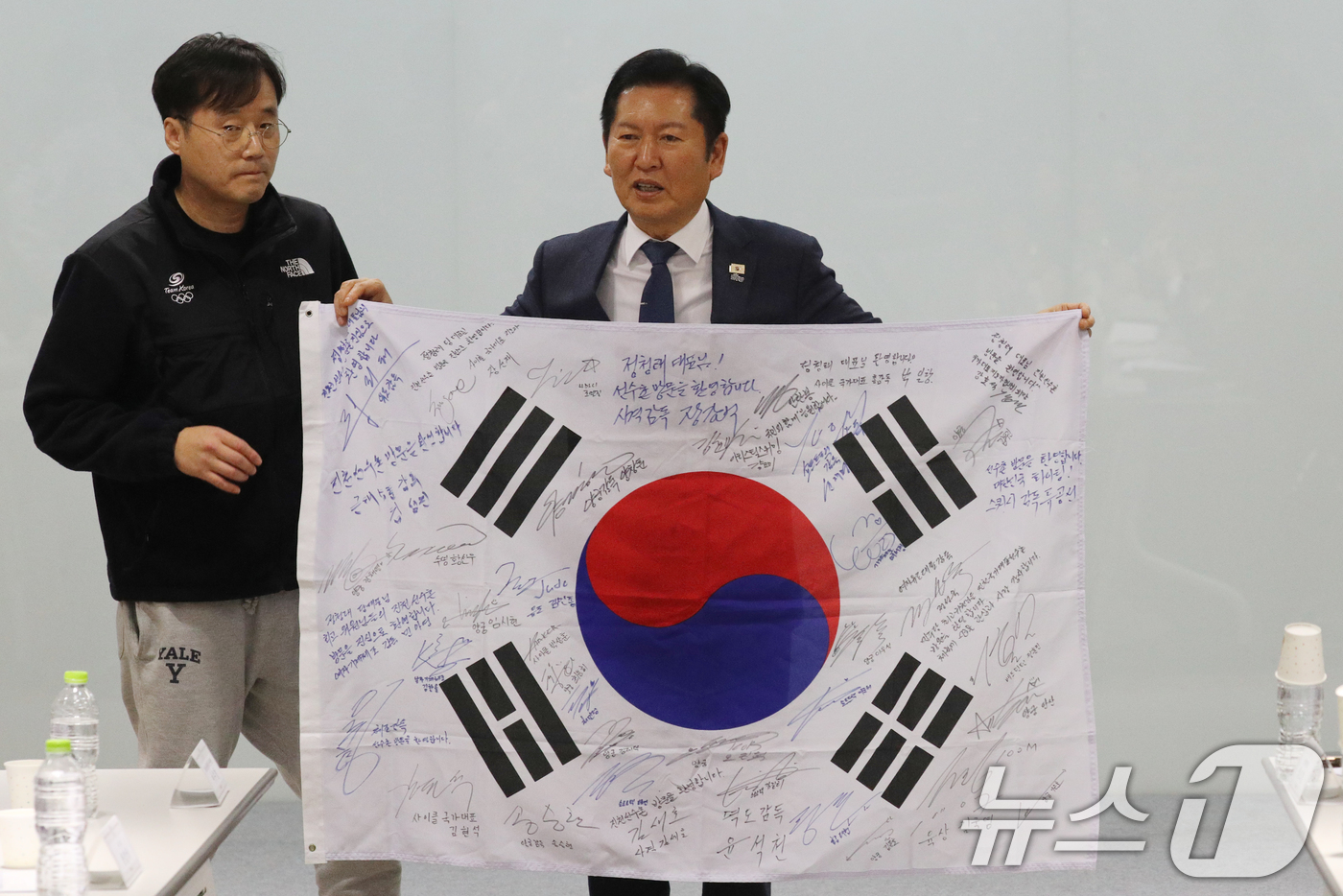 (진천=뉴스1) 김용빈 기자 = 정청래 더불어민주당 대표가 23일 충북 진천국가대표선수촌에서 국가대표지도자 간담회에서 지도자들의 사인이 담긴 태극기를 선물받고 있다.2026.1.2 …