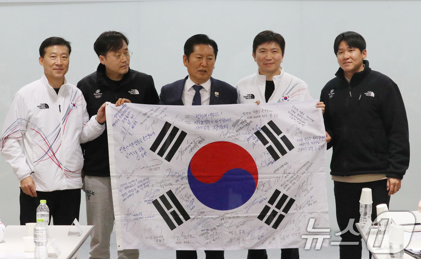 (진천=뉴스1) 김용빈 기자 = 정청래 더불어민주당 대표가 23일 충북 진천국가대표선수촌에서 국가대표지도자 간담회에서 지도자들의 사인이 담긴 태극기를 선물받고 있다. 2026.1. …