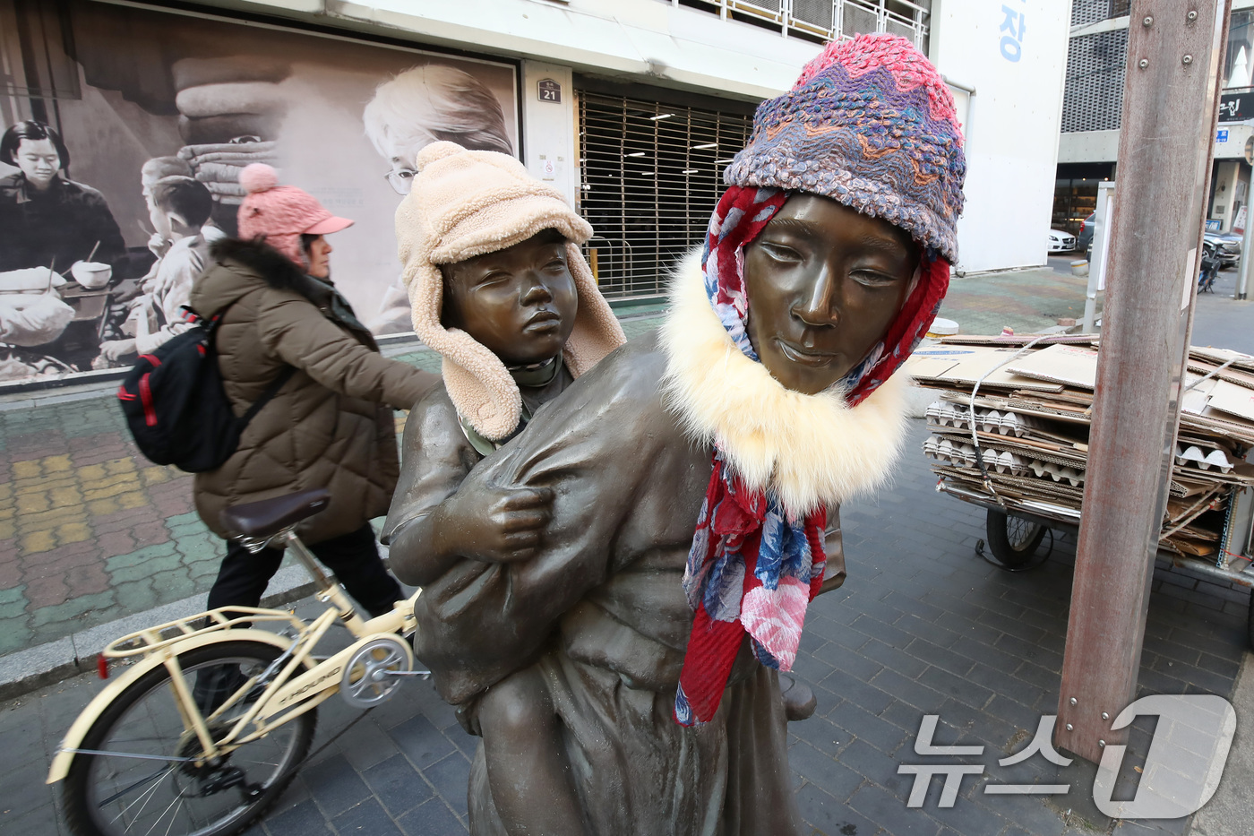 (대구=뉴스1) 공정식 기자 = 동장군이 기승을 부린 23일 오후 대구 중구 종로 약령시 인근에 세워진 '엄마의 마음' 조각상(이현우 작)에 시민들이 씌워놓은 방한모와 목도리가 눈 …
