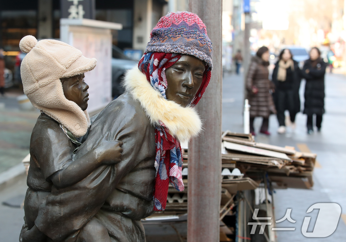 (대구=뉴스1) 공정식 기자 = 동장군이 기승을 부린 23일 오후 대구 중구 종로 약령시 인근에 세워진 '엄마의 마음' 조각상(이현우 작)에 시민들이 씌워놓은 방한모와 목도리가 눈 …