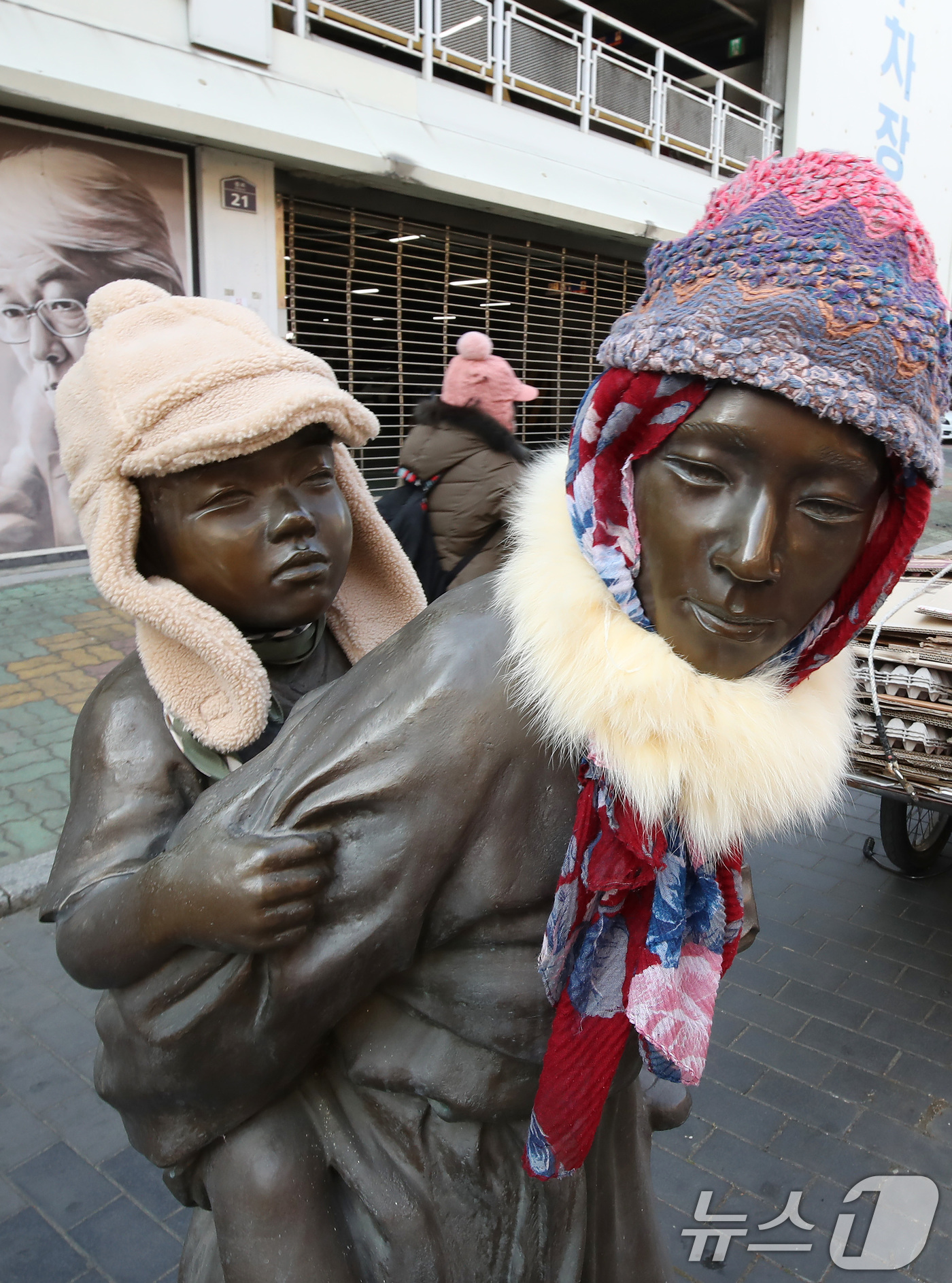 (대구=뉴스1) 공정식 기자 = 동장군이 기승을 부린 23일 오후 대구 중구 종로 약령시 인근에 세워진 '엄마의 마음' 조각상(이현우 작)에 시민들이 씌워놓은 방한모와 목도리가 눈 …