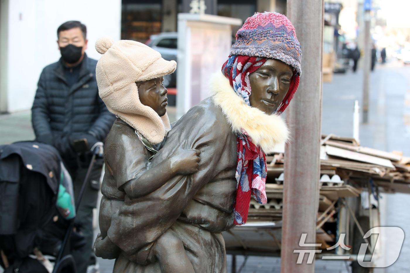 (대구=뉴스1) 공정식 기자 = 동장군이 기승을 부린 23일 오후 대구 중구 종로 약령시 인근에 세워진 '엄마의 마음' 조각상(이현우 작)에 시민들이 씌워놓은 방한모와 목도리가 눈 …