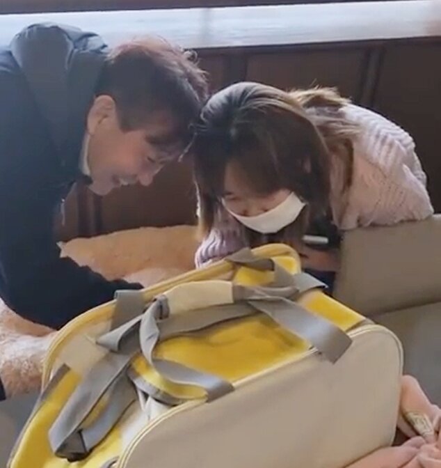 본문 이미지 - 삼순이 입양하는 날, 수진 씨 부모님이 이동 가방에 들어간 삼순이를 보고 인사하고 있다(강수진 제공). ⓒ 뉴스1