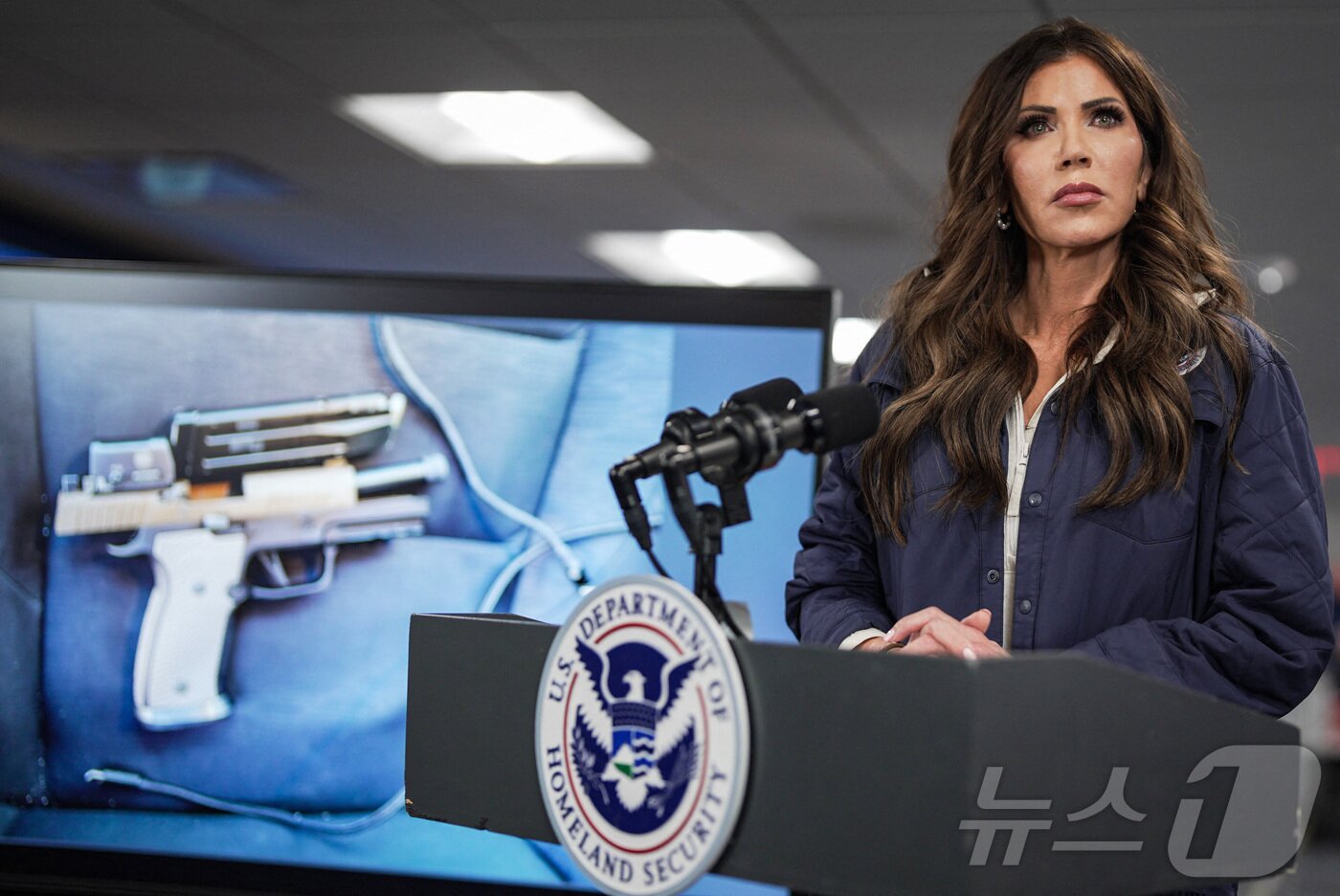 본문 이미지 - 크리스티 놈 국토안보부 장관이 지난 24일(현지시간) 미네소타주 미니애폴리스에서 발생한 총격 사건 이후 기자회견을 통해 이민 요원들이 회수한 권총 사진을 공개하고 있다. 2026.1.24 ⓒ AFP=뉴스1 ⓒ News1 김경민 기자