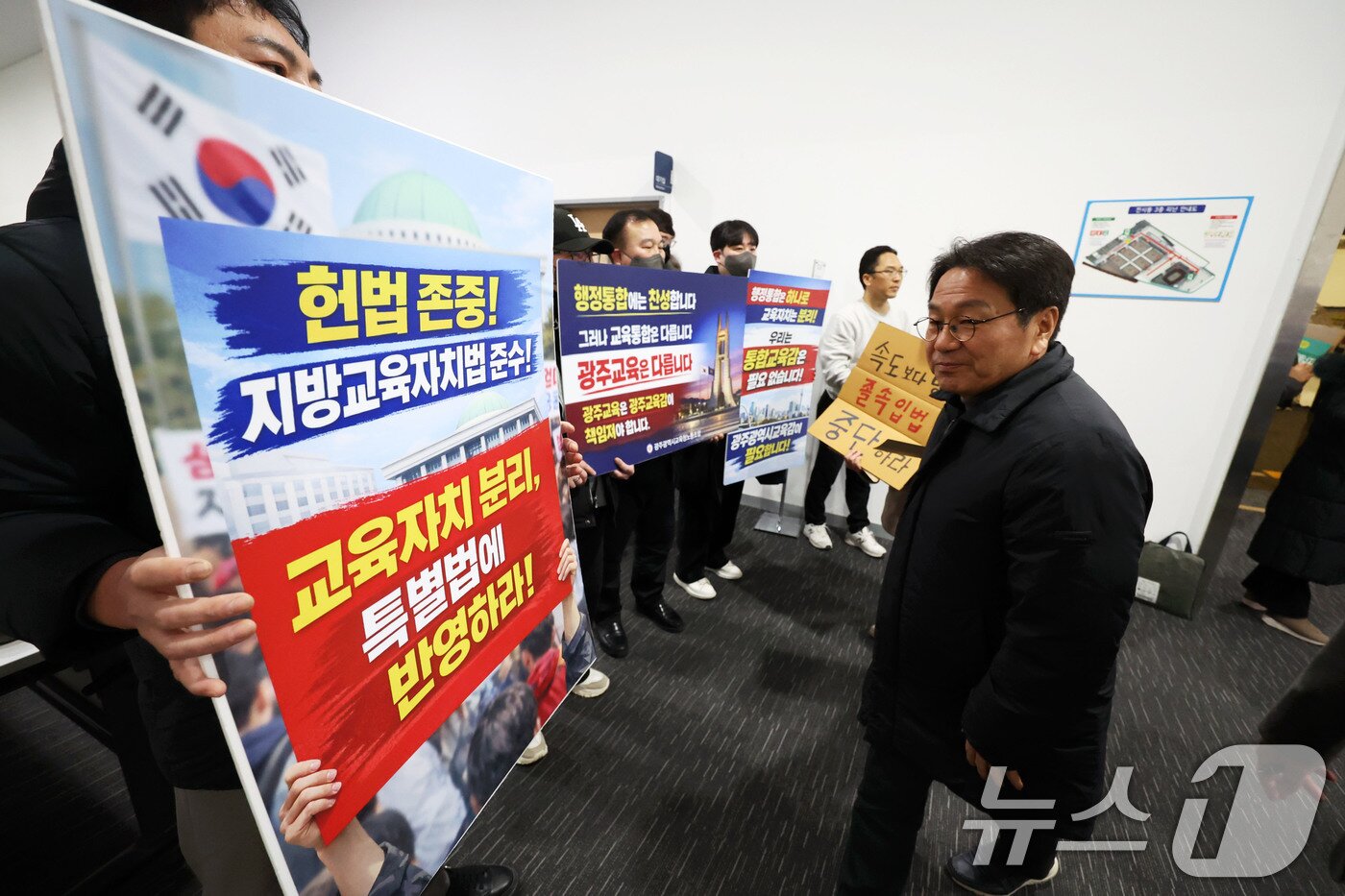 본문 이미지 - 강기정 광주시장이 25일 광주 서구 김대중컨벤션센터에서 열린 광주전남 행정통합 특별법 제정을 위한 간담회에 참석하며 광주시교육청 노동조합 노조원들의 교육자치 분리를 촉구하는 피켓시위를 바라보고 있다. 2026.1.25/뉴스1 ⓒ News1 이승현 기자